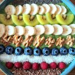 Vibrant smoothie bowl topped with assorted fruits, walnuts, and seeds, perfect for a healthy start.