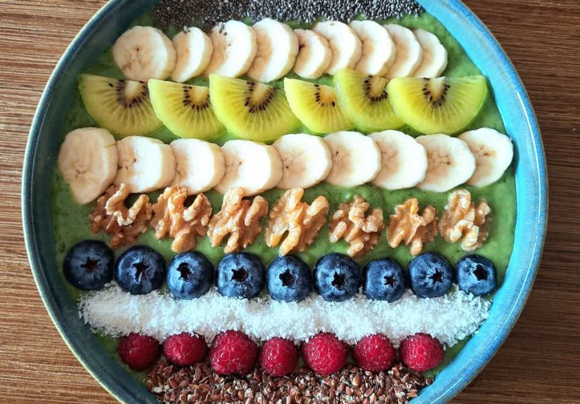Vibrant smoothie bowl topped with assorted fruits, walnuts, and seeds, perfect for a healthy start.